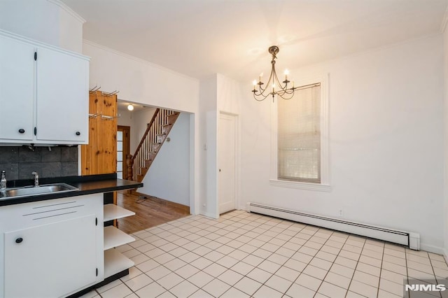 118 W 49th St, Bayonne, NJ 07002 - unfurnished dining area with a notable chandelier, a sink, baseboard heating, stairs, and ornamental molding