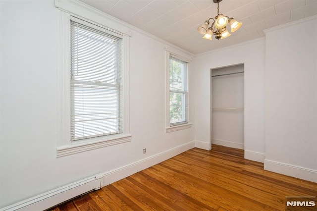 118 W 49th St, Bayonne, NJ 07002 - unfurnished bedroom with an inviting chandelier, ornamental molding, a closet, and wood finished floors