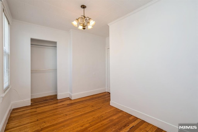 118 W 49th St, Bayonne, NJ 07002 - unfurnished bedroom featuring crown molding, baseboards, wood finished floors, and a chandelier