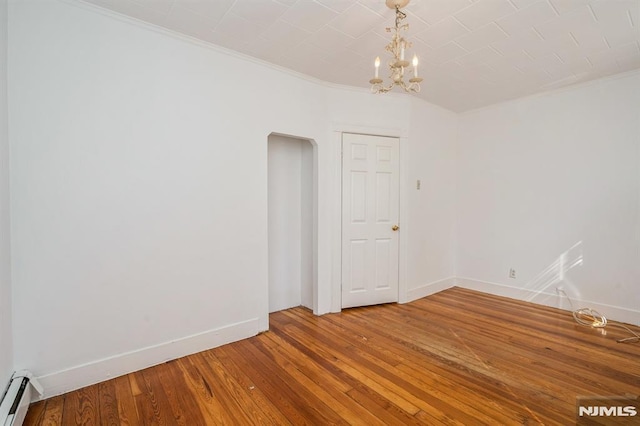 118 W 49th St, Bayonne, NJ 07002 - empty room featuring baseboards, wood-type flooring, a baseboard heating unit, an inviting chandelier, and ornamental molding