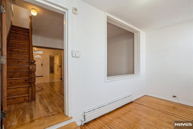118 W 49th St, Bayonne, NJ 07002 - interior space featuring baseboards, stairs, wood finished floors, and baseboard heating