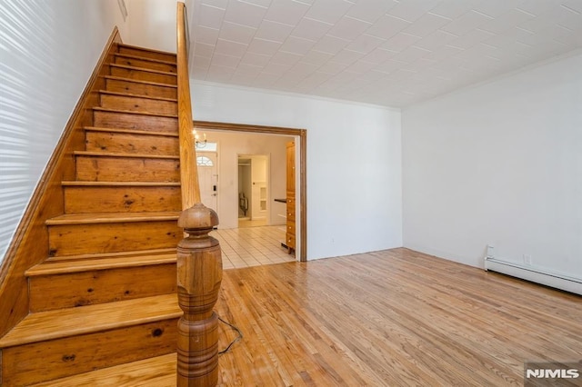 118 W 49th St, Bayonne, NJ 07002 - staircase with crown molding, a baseboard radiator, and wood finished floors