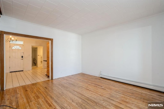 118 W 49th St, Bayonne, NJ 07002 - unfurnished room featuring crown molding, a notable chandelier, wood finished floors, and baseboard heating