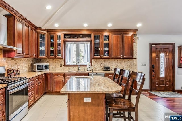 142 Brookfield Ave, Nutley, NJ 07110 - kitchen featuring a sink, light stone counters, stainless steel appliances, and wall chimney exhaust hood