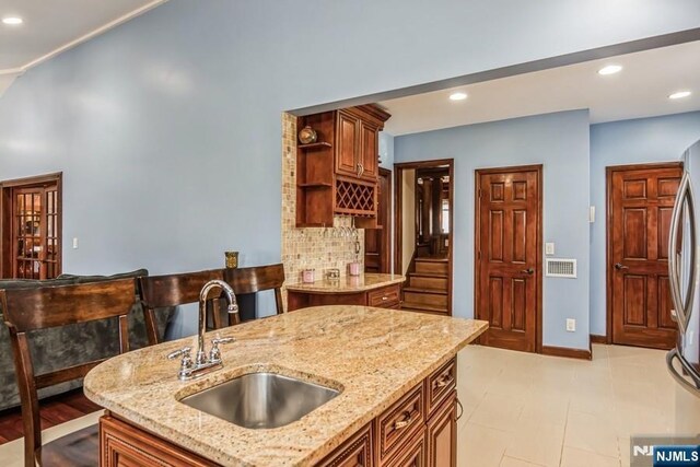 142 Brookfield Ave, Nutley, NJ 07110 - kitchen with open shelves, light stone counters, a sink, decorative backsplash, and visible vents