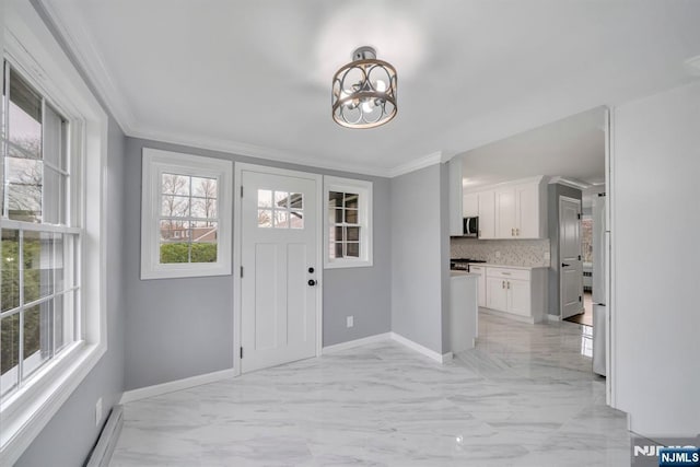 entrance foyer with baseboards, a chandelier, a wealth of natural light, and marble finish floor