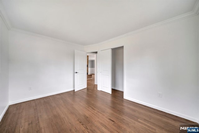 unfurnished bedroom featuring crown molding, baseboards, a closet, and dark wood-type flooring