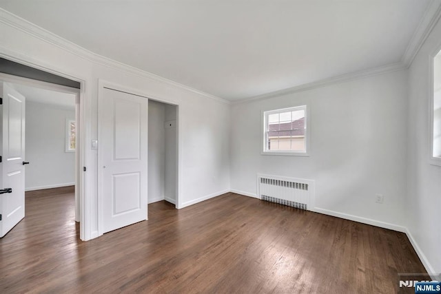 unfurnished bedroom with crown molding, dark wood finished floors, baseboards, a closet, and radiator heating unit
