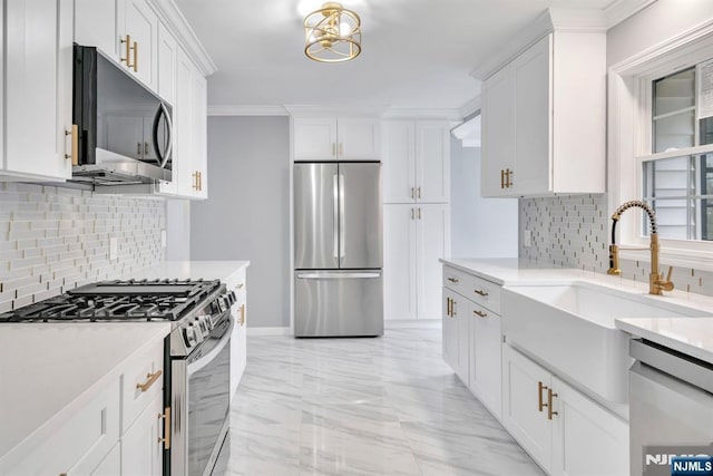 kitchen with backsplash, stainless steel appliances, white cabinets, and light countertops