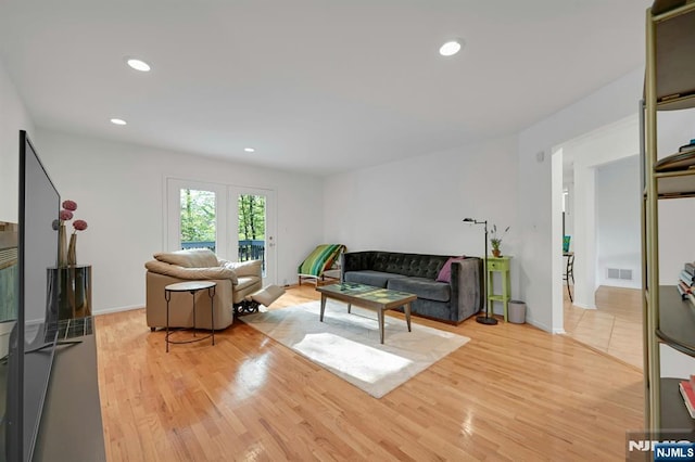 living room with light wood-style floors, baseboards, recessed lighting, and visible vents