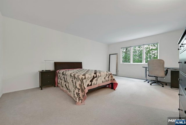 bedroom featuring baseboards and light colored carpet