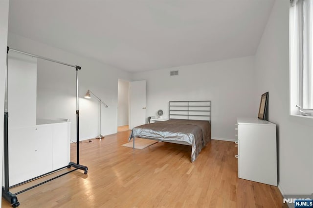 bedroom with light wood-style flooring and visible vents