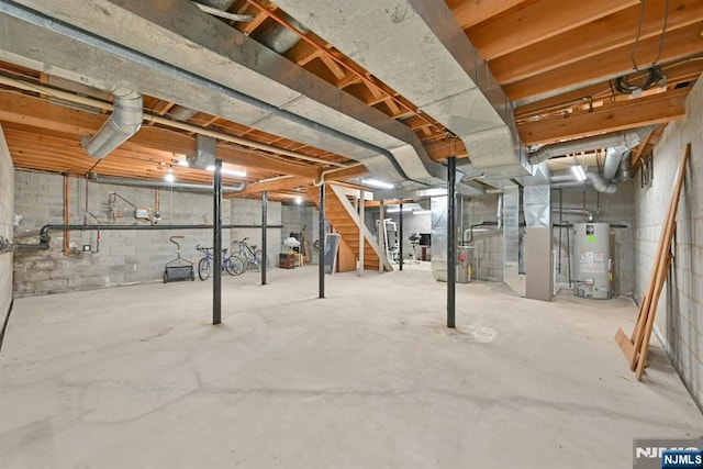 unfinished basement with stairway, heating unit, and water heater