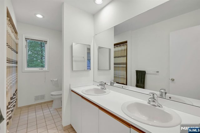 full bath featuring double vanity, toilet, visible vents, and a sink