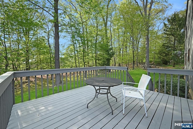 wooden terrace featuring a lawn