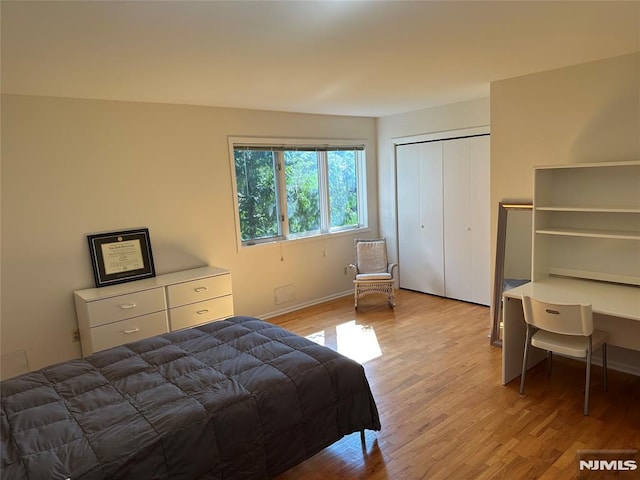bedroom featuring a closet, baseboards, and light wood-style floors