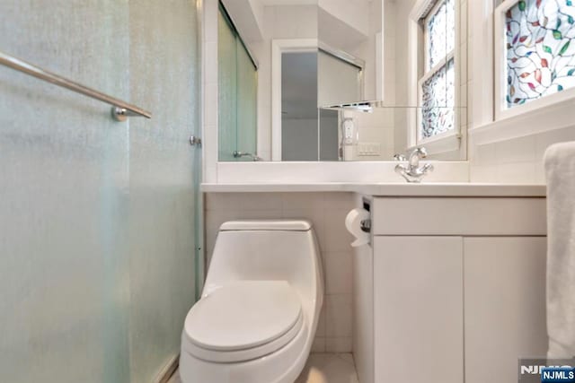 full bathroom featuring vanity, toilet, tile walls, and a stall shower