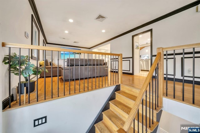 staircase with visible vents, recessed lighting, crown molding, and wood finished floors