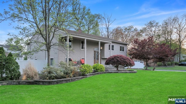 raised ranch featuring a chimney and a front yard