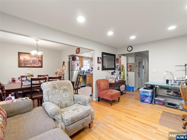 living room with recessed lighting, light wood-style flooring, and a notable chandelier