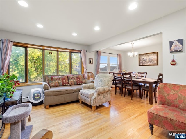 living area with light wood-style floors, recessed lighting, a baseboard heating unit, and a chandelier
