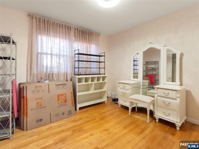 bedroom featuring multiple windows and light wood-style floors