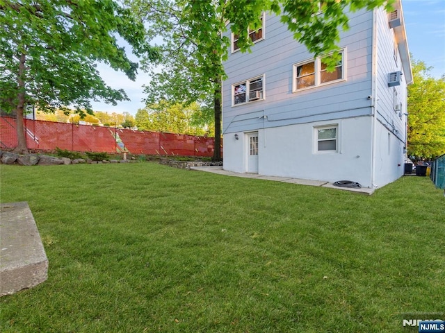 rear view of property featuring a fenced backyard and a yard