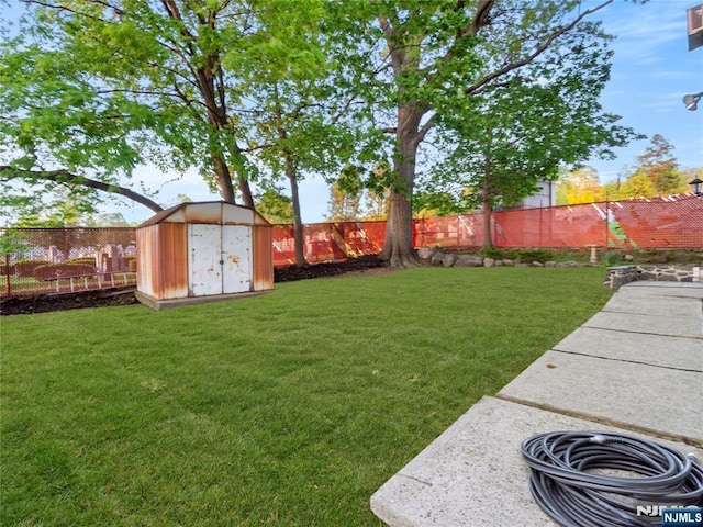 view of yard with a storage unit, a fenced backyard, and an outdoor structure