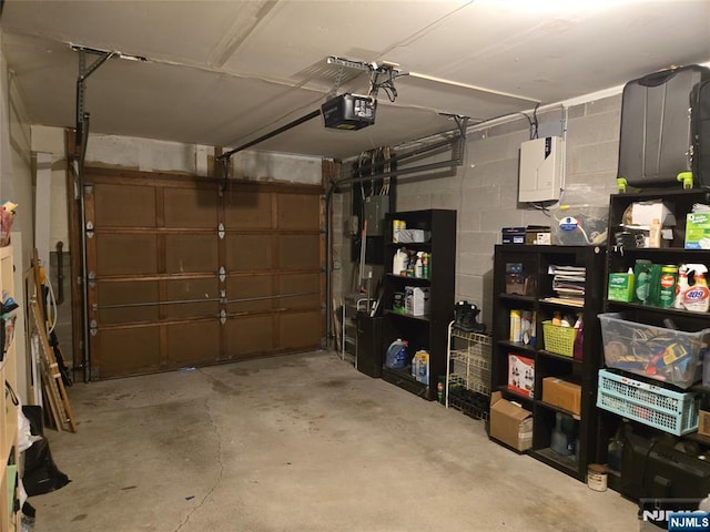 garage with concrete block wall and a garage door opener