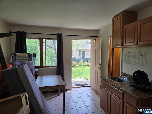 doorway to outside featuring light tile patterned floors and a sink
