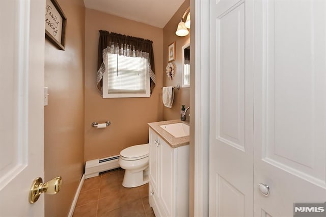 half bath with baseboard heating, tile patterned floors, baseboards, vanity, and toilet