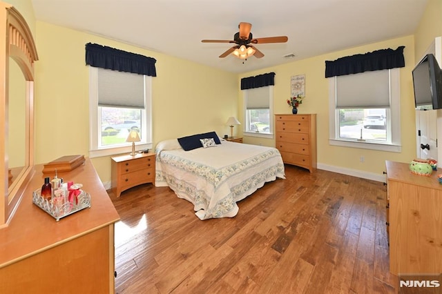 bedroom featuring light wood-style floors, a ceiling fan, baseboards, and visible vents