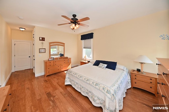 bedroom featuring baseboards, a ceiling fan, and light wood finished floors