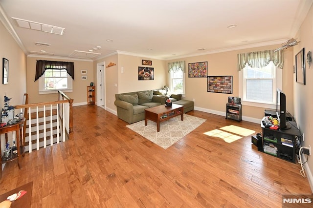 living room featuring visible vents, plenty of natural light, wood finished floors, and attic access