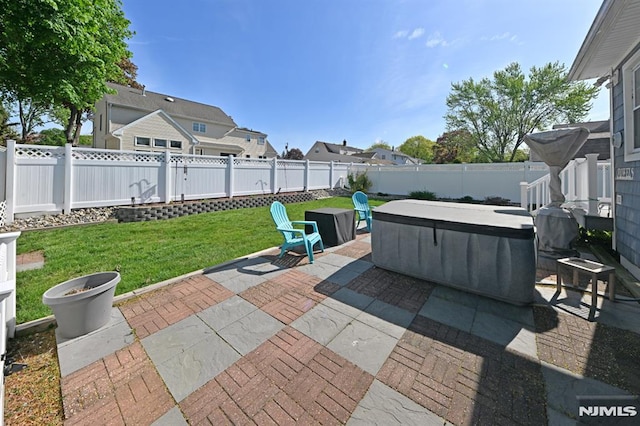 view of patio with a fenced backyard, a hot tub, and a residential view