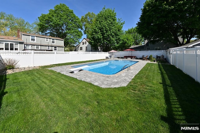 view of swimming pool featuring a diving board, a fenced backyard, a fenced in pool, a patio area, and a yard