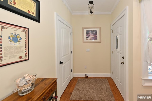 doorway to outside with baseboards, ornamental molding, and wood finished floors