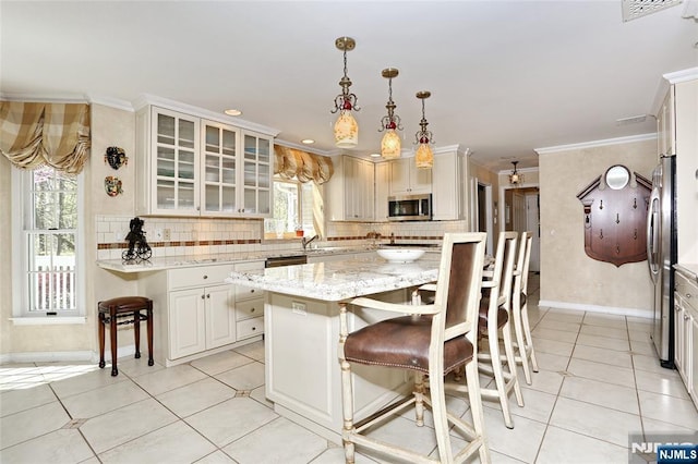 kitchen with appliances with stainless steel finishes, plenty of natural light, baseboards, tasteful backsplash, and crown molding