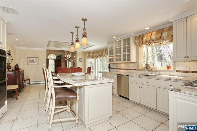 kitchen featuring dishwasher, a sink, light tile patterned floors, healthy amount of natural light, and ornamental molding