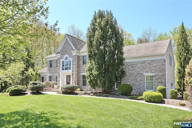 view of front of house with a front yard and brick siding