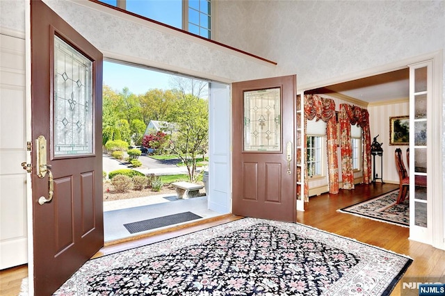 entrance foyer with wood finished floors and ornamental molding