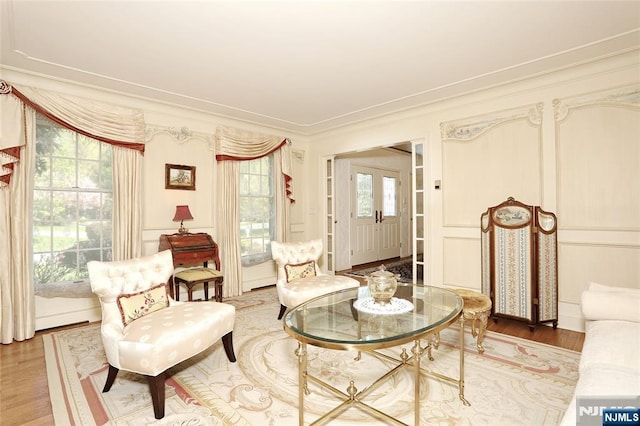 living area with light wood finished floors and ornamental molding
