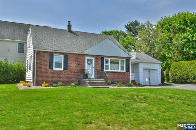view of front of home with brick siding, a chimney, a front yard, and a garage