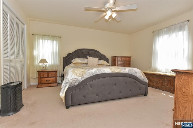 carpeted bedroom with a ceiling fan and a closet