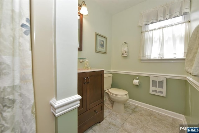 full bathroom with vanity, toilet, tile patterned floors, baseboards, and heating unit