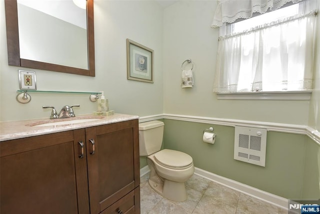 half bath featuring vanity, toilet, tile patterned floors, baseboards, and heating unit