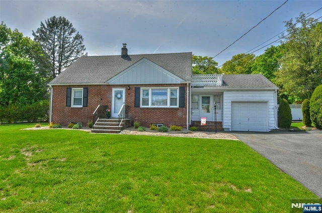 view of front facade featuring a front lawn, brick siding, a garage, aphalt driveway, and a chimney