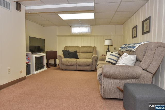 carpeted living room with baseboards, a drop ceiling, and visible vents