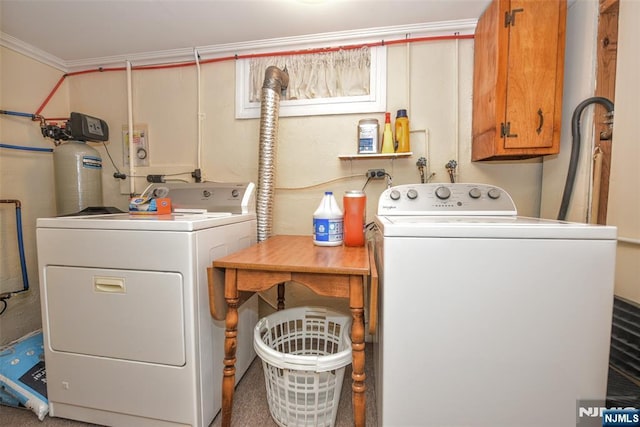 laundry room with washing machine and clothes dryer, ornamental molding, and cabinet space