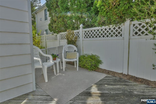 view of patio / terrace featuring fence and a deck
